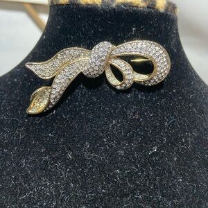 Gold Tone Ribbon Brooch With Rhinestones.